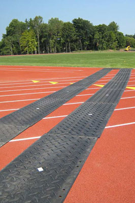 Ground protection mats laid over an athletics course to protect it from vehicles driving over it