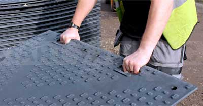 person dragging a ground protection mat