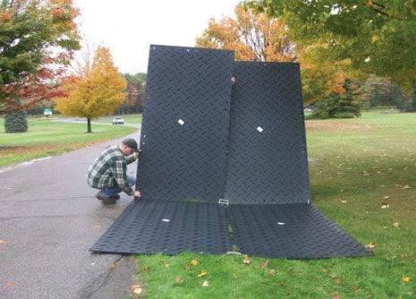 Men connecting two ground protection mats with double and single connectors